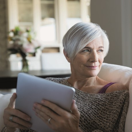 woman with white hair reading on iPad