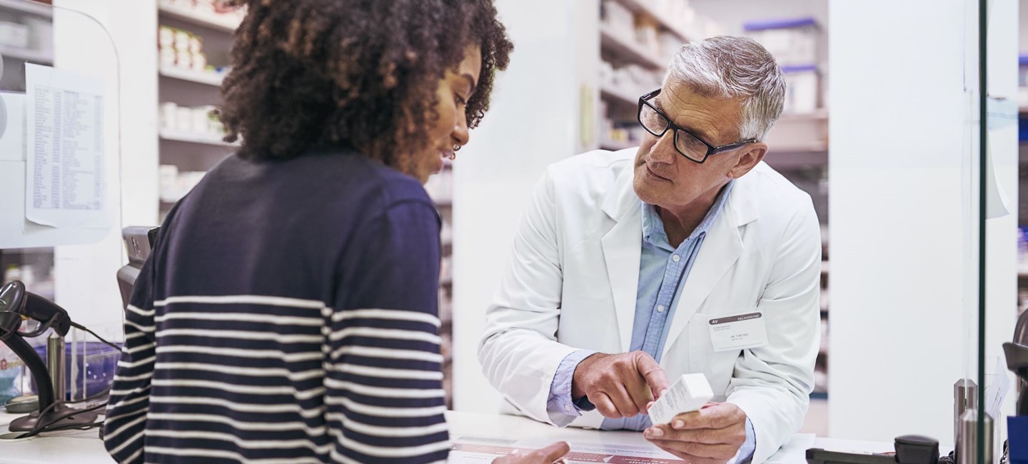 a young woman speaking with male pharmacist