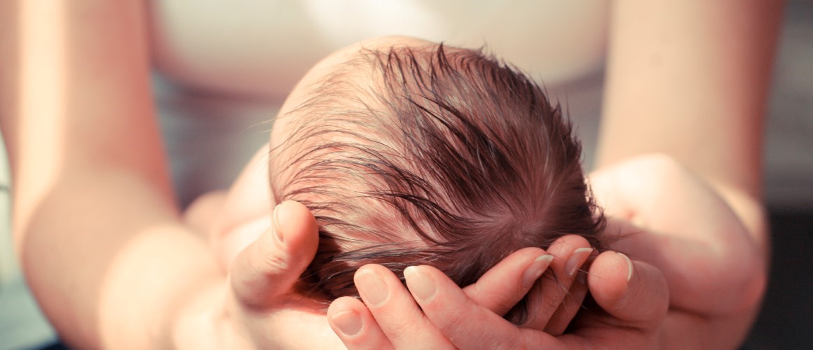 Woman holding newborn infant in her arms. 