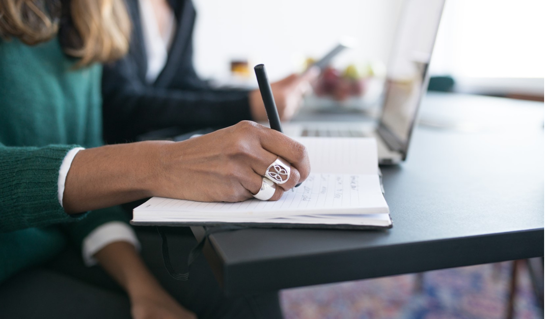 A woman at a desk taking notes1120x680