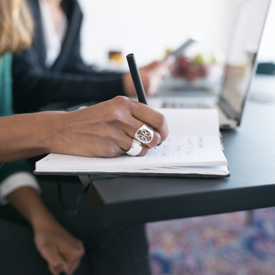 A woman at a desk taking notes920x920